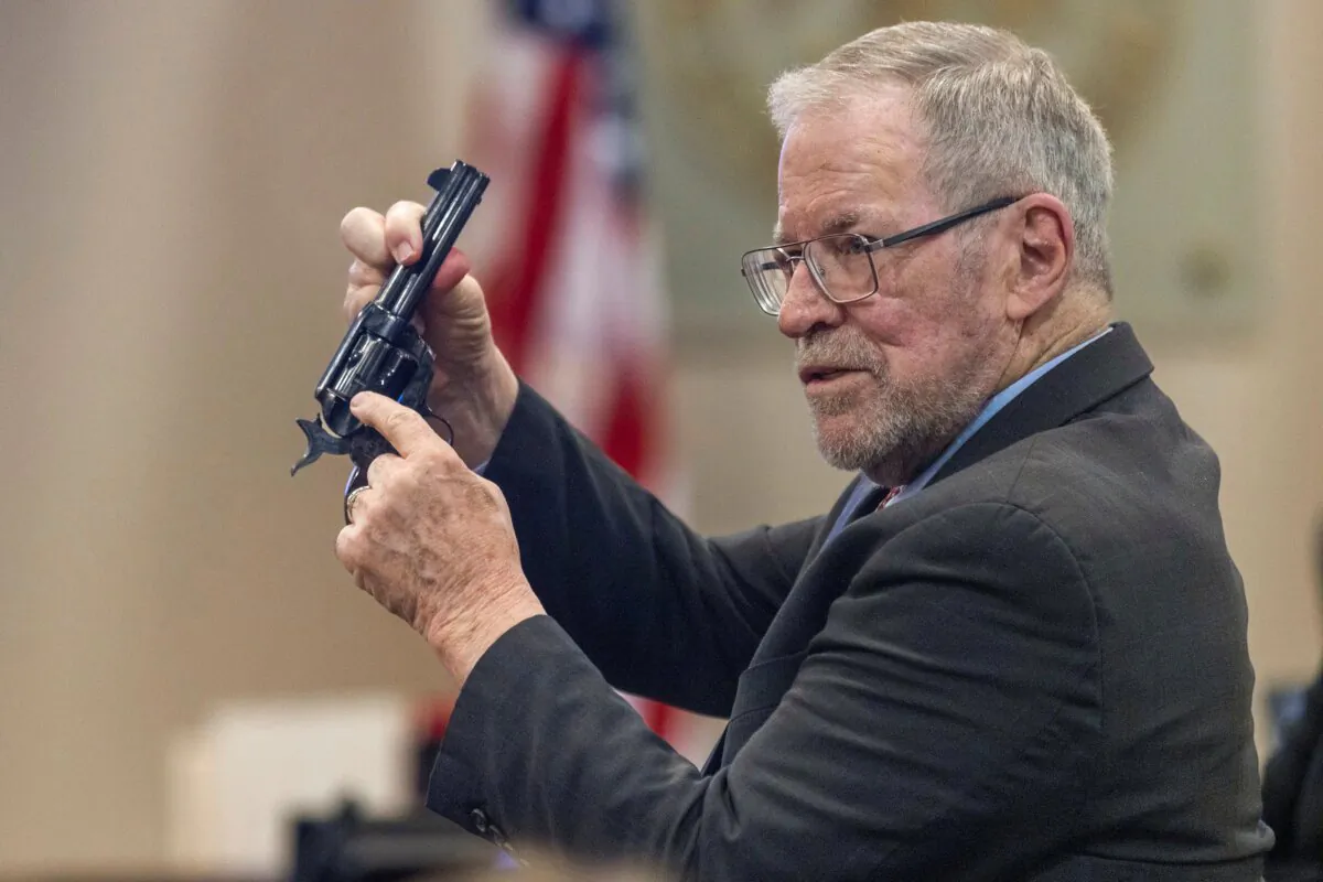 Lucien Haag, a witness on forensic science firearms evidence examination and shooting reconstruction, shows the jury a gun like the one used in rehearsal for the film "Rust" during the Hanna Gutierrez-Reed trial at District Court in Santa Fe, N.M., on Feb. 27, 2024. (Luis Sánchez Saturno/Santa Fe New Mexican via AP)