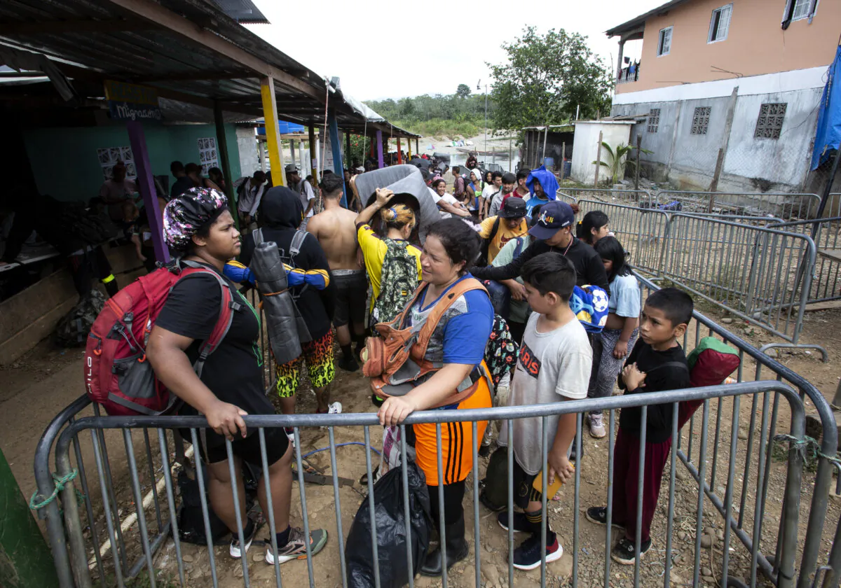 Migrants are herded through an immigration checkpoint after being ferried by canoe to Bajo Chiquito, Panama, on Feb. 18, 2024. Bajo Chiquito is the first camp after crossing the Darien Gap from Colombia into Panama. (Bobby Sanchez for The Epoch Times)