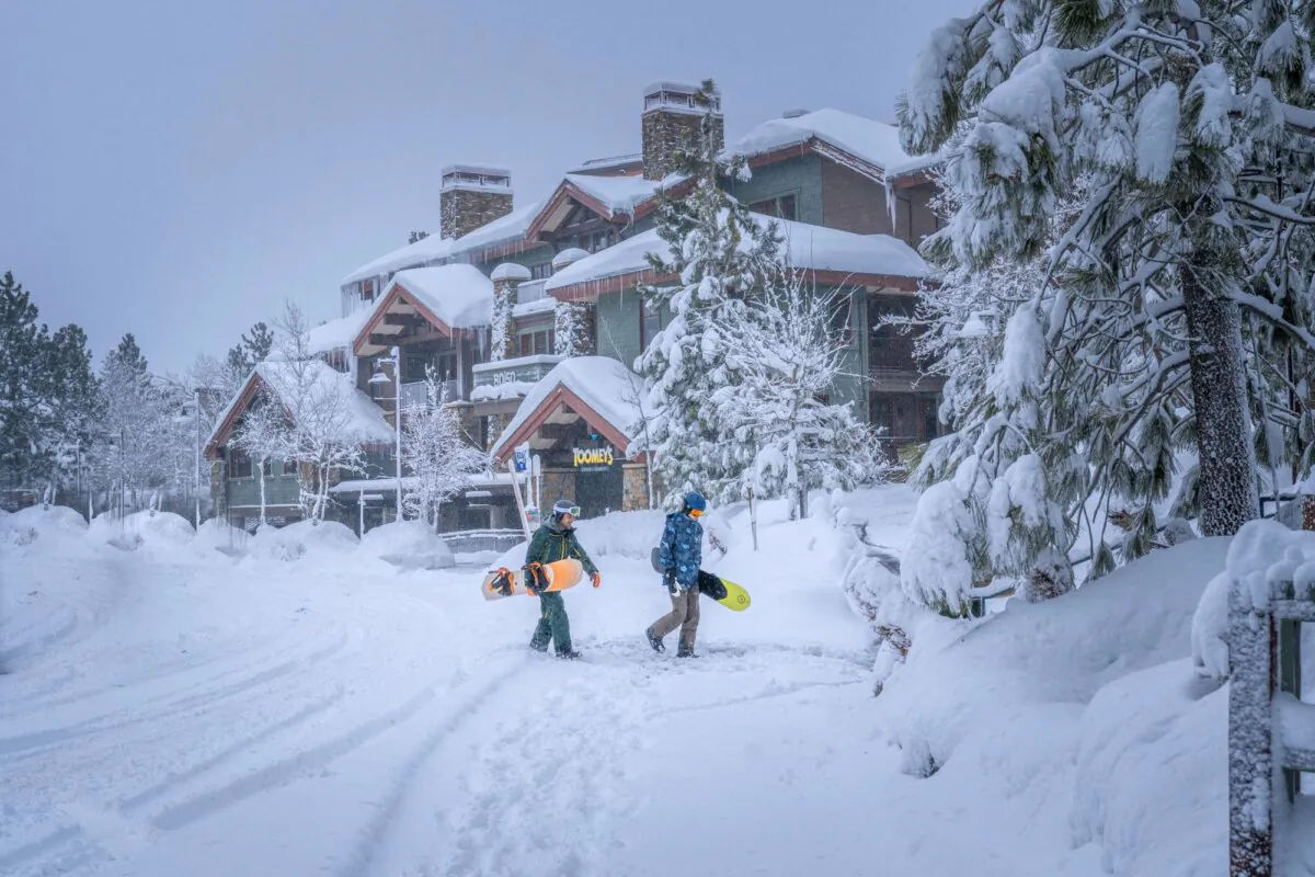 Snowboarders walk in the snow in Mammoth Lakes, Calif., on Feb. 19, 2024. (Jacob Myhre/Mammoth Lakes Tourism via AP)