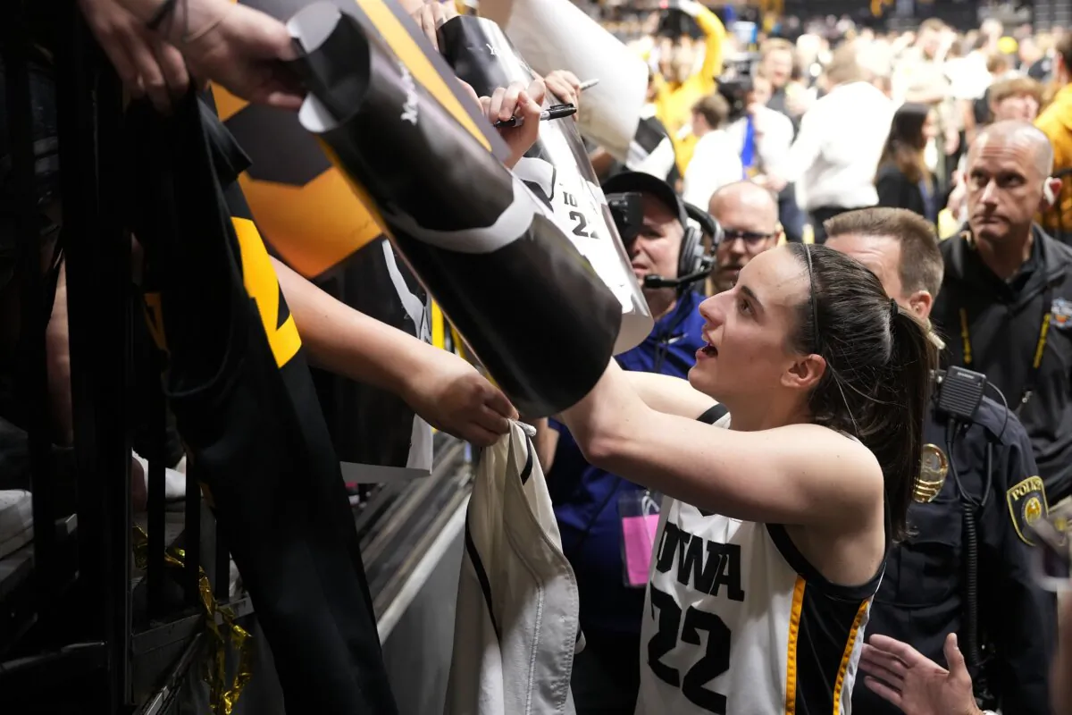 Iowa guard Caitlin Clark (22) signs autographs after the team's win over Michigan in an NCAA college basketball game in Iowa City, Iowa, on Feb. 15, 2024. (Matthew Putney/AP Photo)