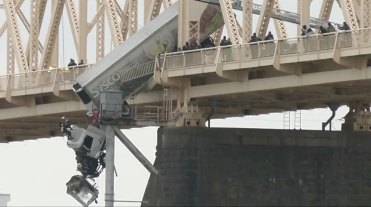 Louisville emergency crews rescue the driver of semitruck that is dangling off the Clark Memorial Bridge over the Ohio River in Louisville, Ky., on March 1, 2024. (WDRB via AP)