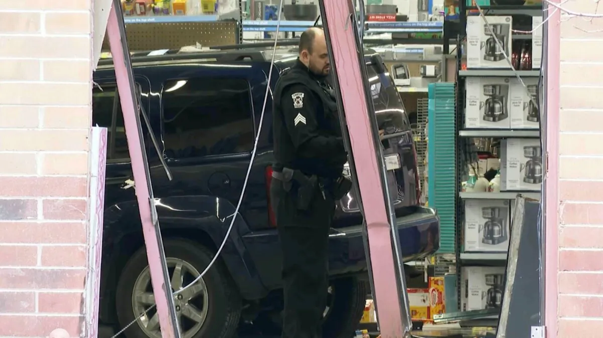 In this photo made from video, a police officer stands in front of a vehicle that crashed into a Walmart store in Canton Township, Mich., on March 1, 2024. (Mike Householder/AP Photo)