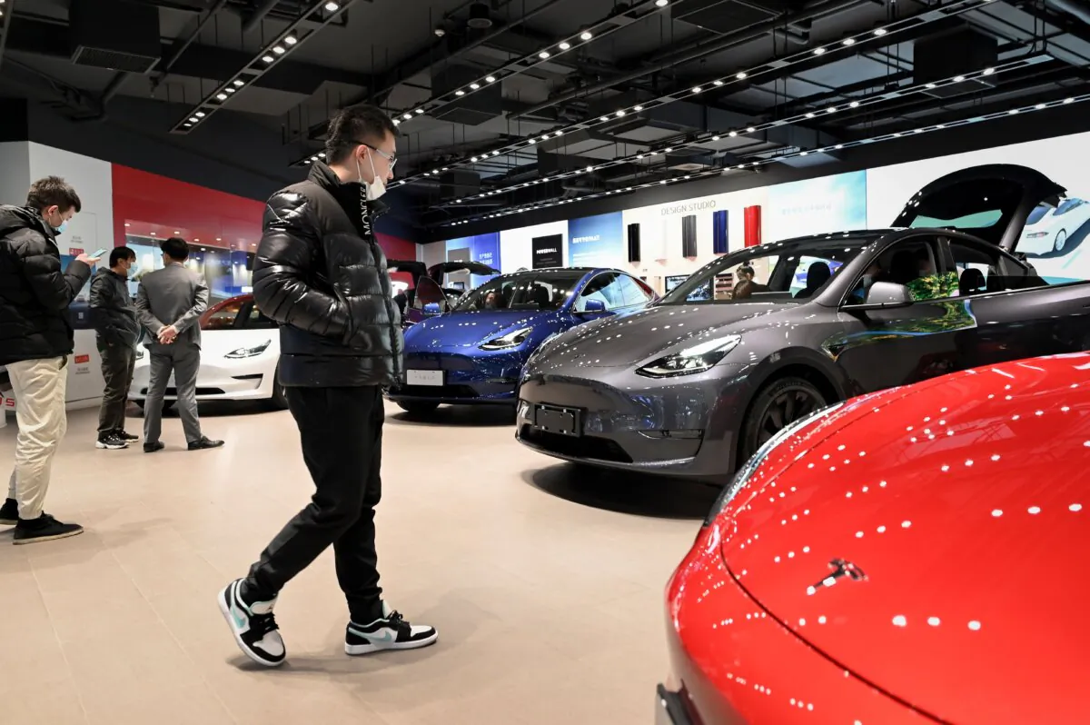 People look at a Tesla Model Y car at a Tesla showroom in Beijing on Jan. 5, 2021. (Wang Zhao/AFP via Getty Images)