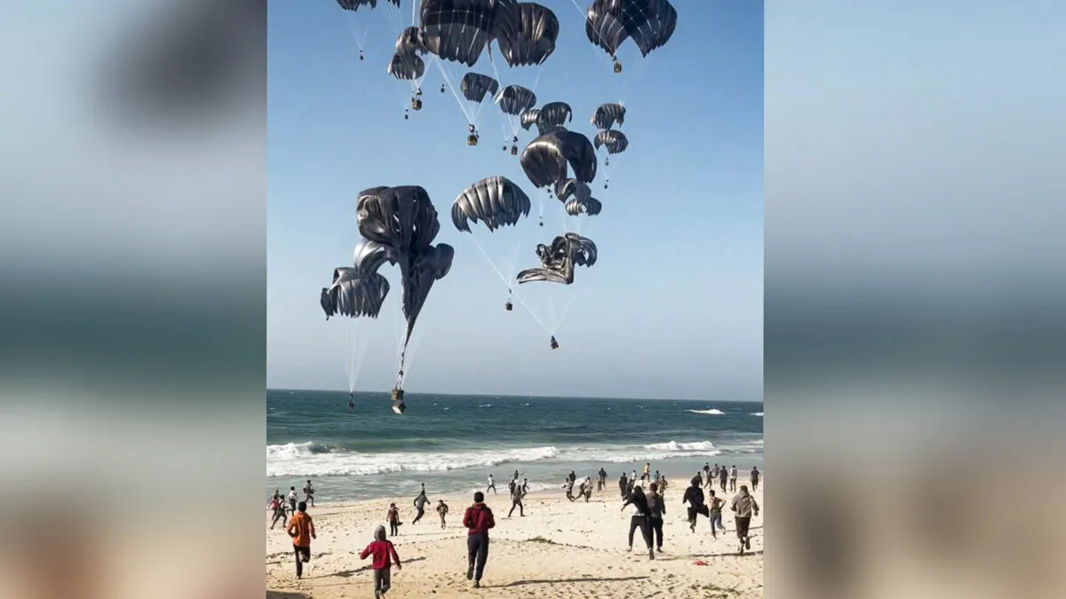 Palestinians run toward parachutes attached to food parcels, air-dropped from U.S. aircrafts on a beach in the Gaza Strip on March 2, 2024. (AFP via Getty Images)