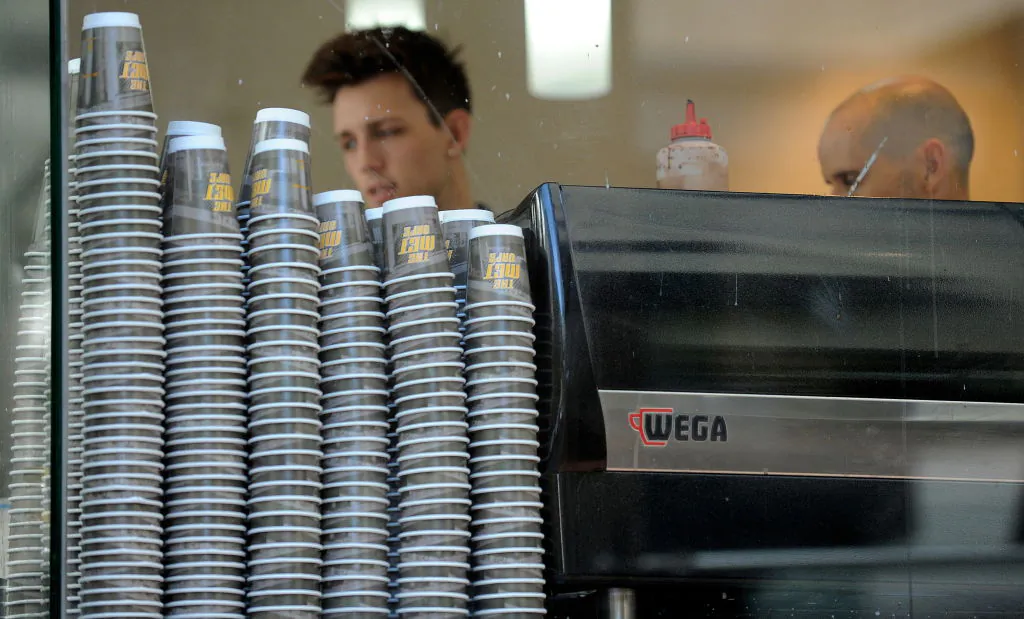Take-away coffee cups are displayed alongside a coffee machine in Sydney, Australia, on April 20, 2010. (Greg Wood/AFP via Getty Images)