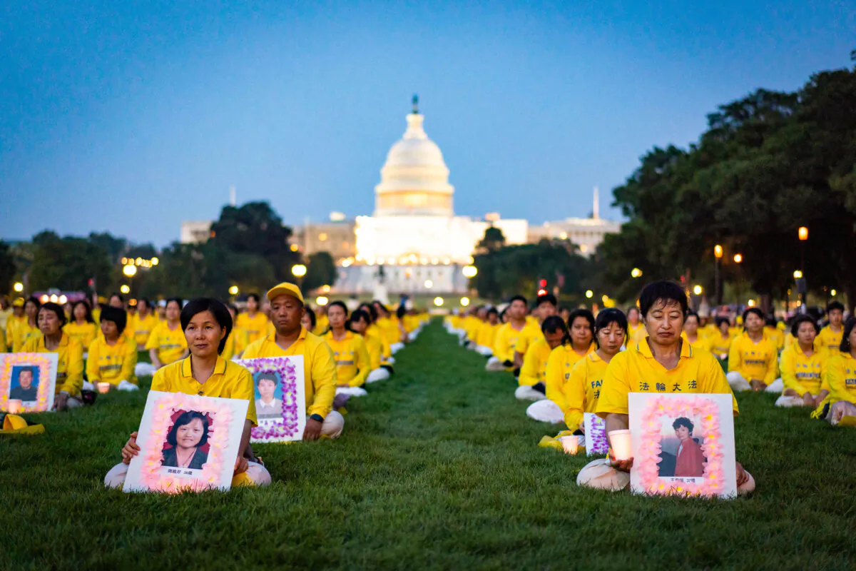 Falun Gong adherents at a candlelight vigil commemorating Falun Gong practitioners who passed away due to the Chinese Communist Party’s 24 years of persecution at the National Mall in Washington on July 20, 2023. (Samira Bouaou/The Epoch Times)