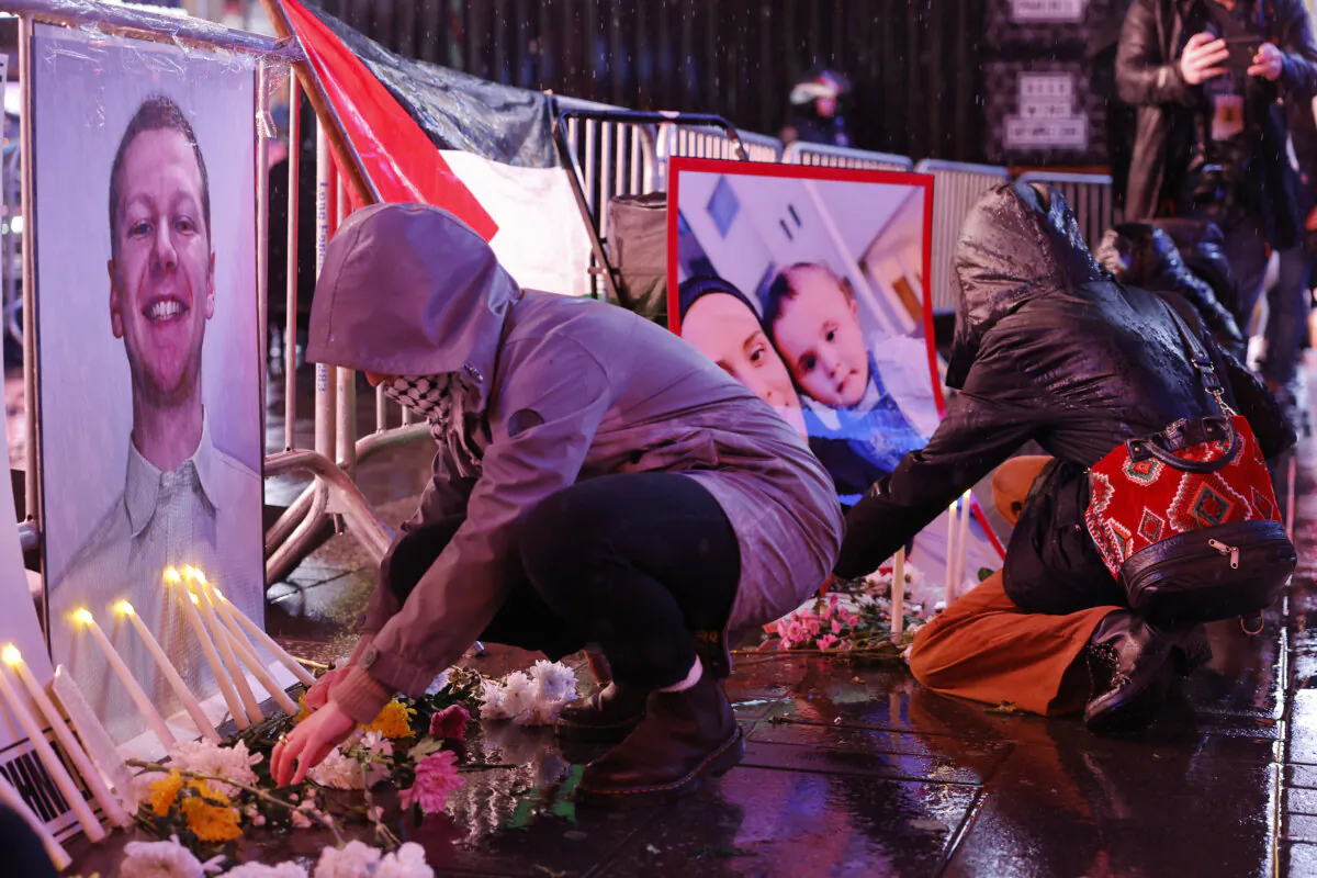 People place flowers in front of photos at a vigil for U.S. Airman Aaron Bushnell at the U.S. Army Recruiting Office in Times Square, New York City, on Feb. 27, 2024. Bushnell died after setting himself on fire outside the Israeli Embassy in Washington, D.C. on Sunday, Feb. 25. (Michael M. Santiago/Getty Images)