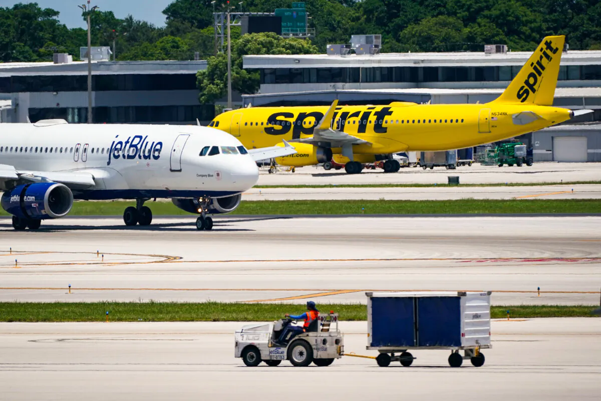 A JetBlue Airways Airbus A320 passes a Spirit Airlines Airbus A320 as it taxis on the runway at the Fort Lauderdale-Hollywood International Airport in Fort Lauderdale, Fla., on July 7, 2022. (Wilfredo Lee/AP Photo)