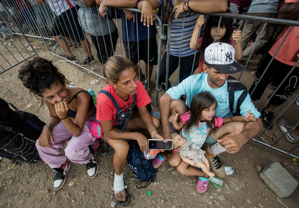 A family from Venezuela rests at Lajas Blancas after crossing the Darien Gap on Feb. 17, 2024. (Bobby Sanchez for The Epoch Times)
