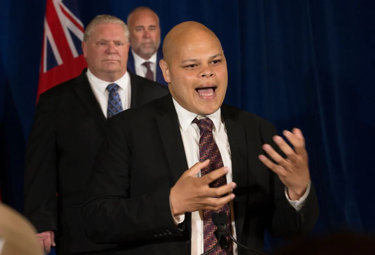Jamil Jivani, then-Ontario's Advocate for Community Opportunities, speaks as Ontario Premier Doug Ford and Then-Minister of Children, Community, and Social Services Todd Smith listen in Toronto on June 4, 2020. (The Canadian Press/Rick Madonik-Pool)