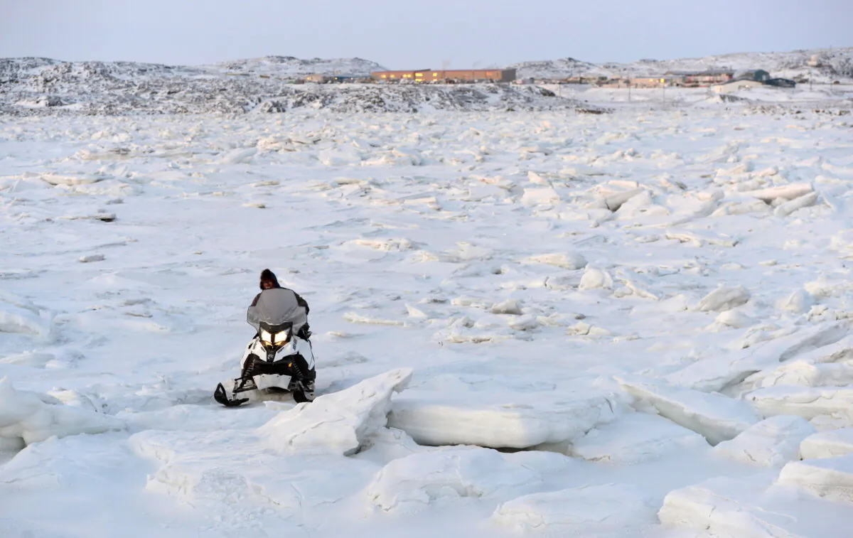 A snowmobiler makes his way through the ice heaves in Frobisher Bay in Iqaluit, Nunavut on Dec. 10, 2014. (THE CANADIAN PRESS/Sean Kilpatrick)