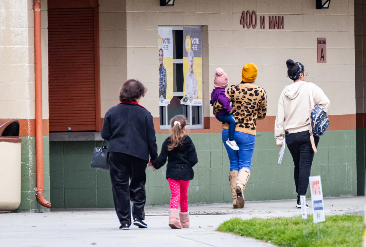 A family walks to a polling station in Orange, Calif., on March 5, 2024. (John Fredricks/The Epoch Times)