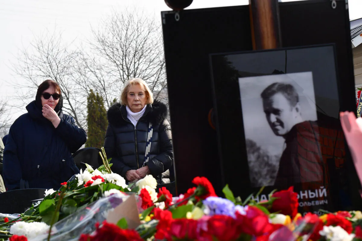 Lyudmila Navalnaya (the woman wearing glasses), mother of Alexei Navalny, accompanied by Alla, mother of Navalny's widow Yulia, visits the grave of her son at the Borisovo cemetery in Moscow on March 2, 2024. (Olga Maltseva/AFP via Getty Images)