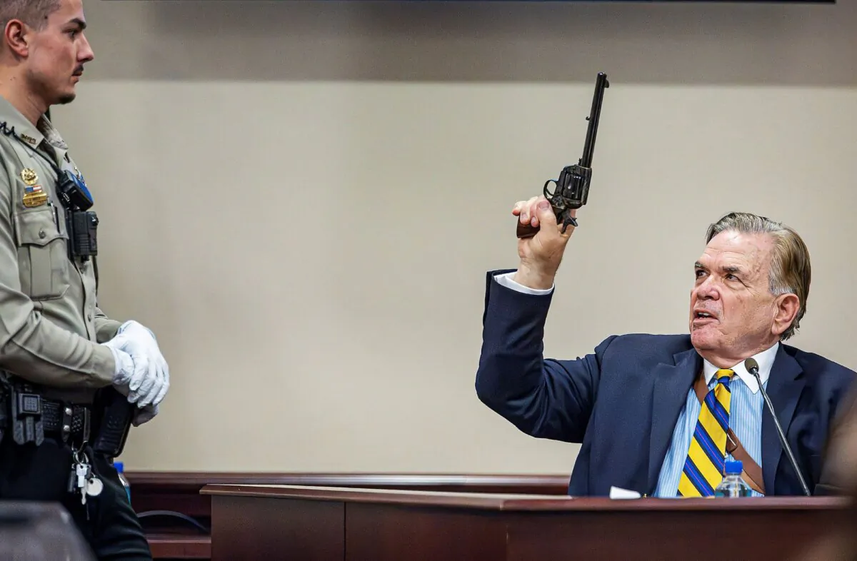 Santa Fe County Deputy Levi Abeyta, (L), watches as expert witness for the defense Frank Koucky III  as Koucky testifies in the involuntary manslaughter trial of movie armorer Hannah Gutierrez-Reed, at the First Judicial District Courthouse in Santa Fe, N.M., on March 5, 2024. (Jim Weber/Pool/Santa Fe New Mexican via AP)