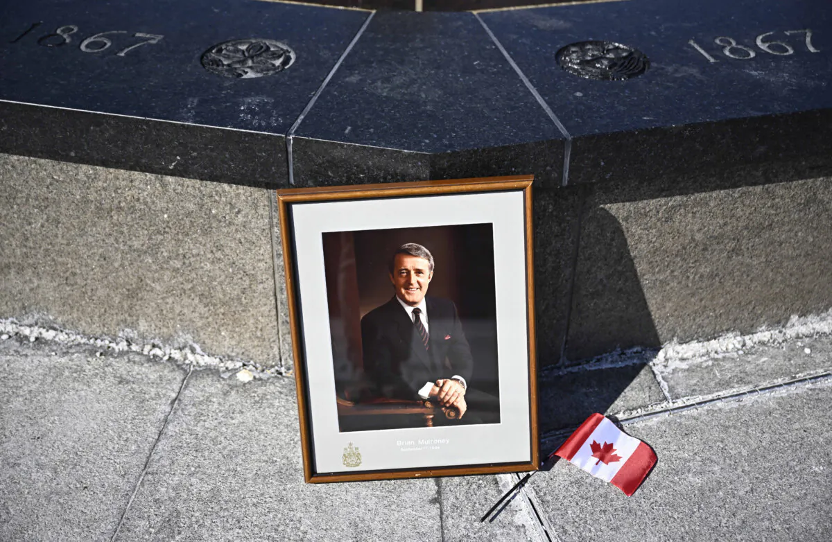 A framed portrait of former prime minister Brian Mulroney leans against the Centennial Flame on Parliament Hill  
as Canadians mourn his death at the age of 84, in Ottawa, on March 1, 2024. (The Canadian Press/Justin Tang)