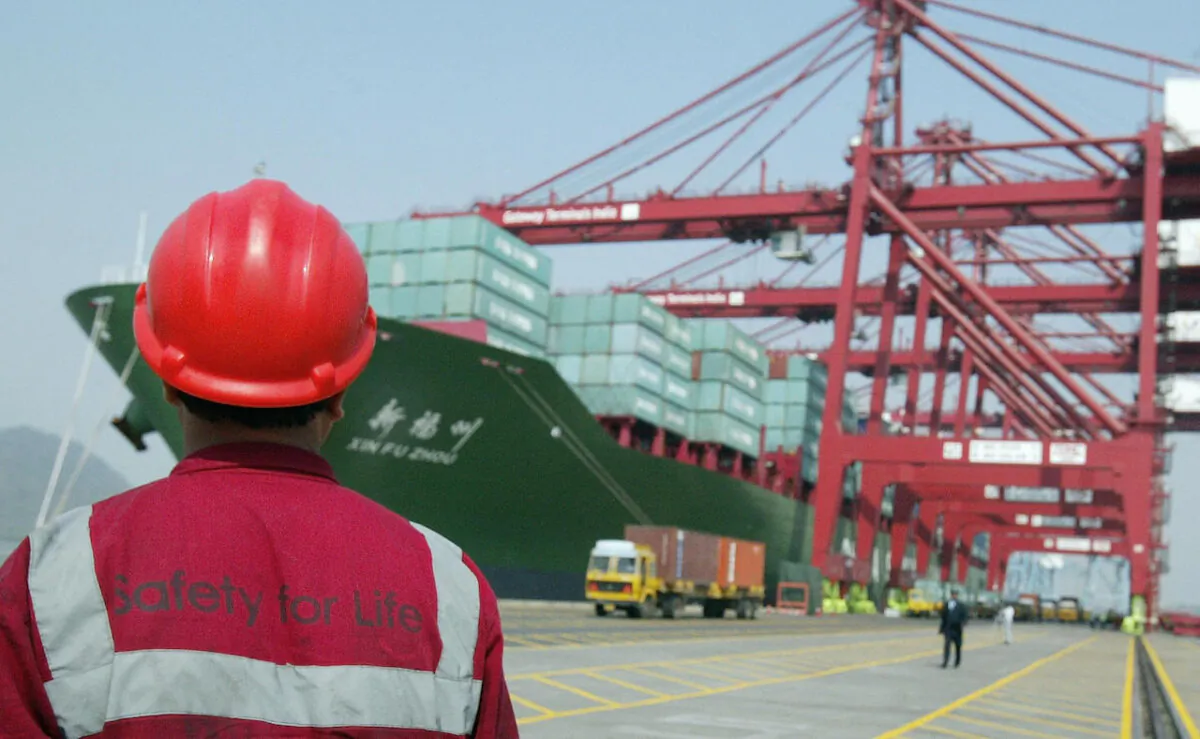 A worker watches operations at the container off-loading terminal on the Jawaharlal Nehru Port Trust premises in Mumbai, India, on Jan. 4, 2007. (INDRANIL MUKHERJEE/AFP via Getty Images)