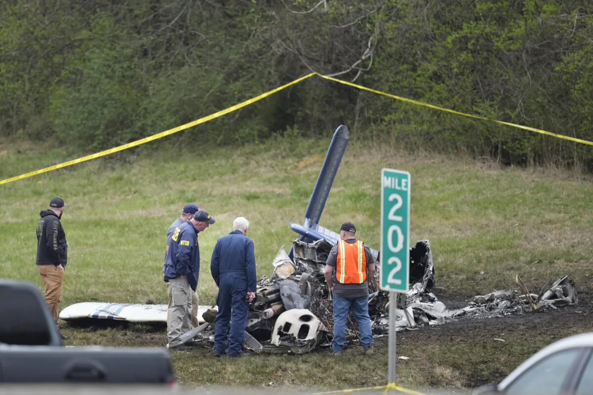Investigators look over a small plane crash alongside eastbound Interstate 40 at mile marker 202, in Nashville, Tenn., on March 5, 2024. (The Associated Press/George Walker IV)