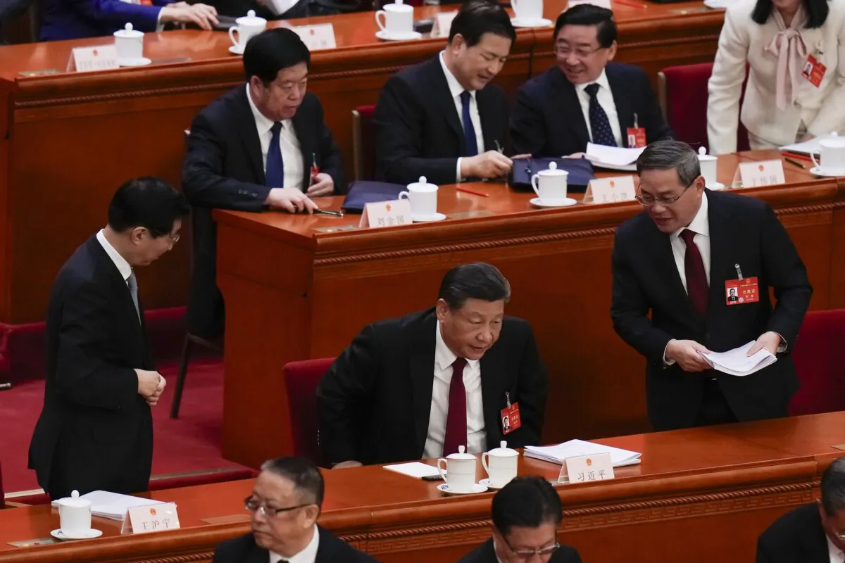 Chinese President Xi Jinping (C) leaves as Chinese Premier Li Qiang (R) looks after the opening session of the National People's Congress (NPC) at the Great Hall of the People in Beijing on March 5, 2024. (Andy Wong/AP Photo)