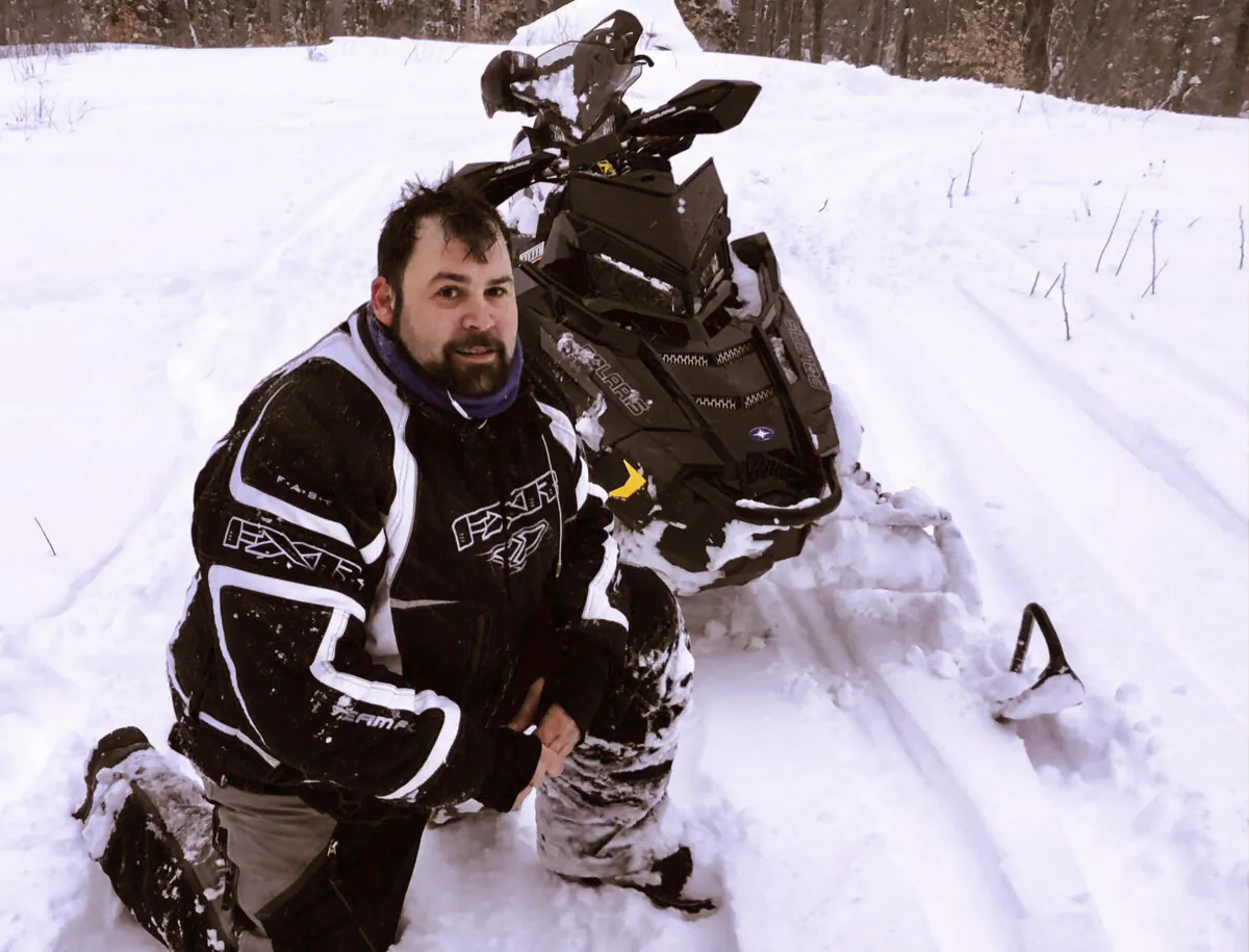 Jeffrey Smith poses with a snowmobile in Windsor, Mass., during March 2018, in this photograph provided by Richard Smith. (Jeffrey Smith photo via AP)