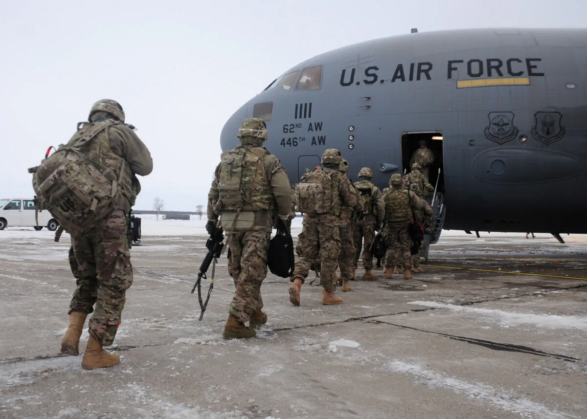 Soldiers from the 2nd Brigade Combat Team, 101st Airborne Division (Air Assault), depart a bus and walk toward a C-17 transport Passenger Transit Center at MK Air Base as a transition point on their way in and out of the U.S. Central Command area of operations. (Staff Sgt. Warren W. Wright Jr., U.S. Army)