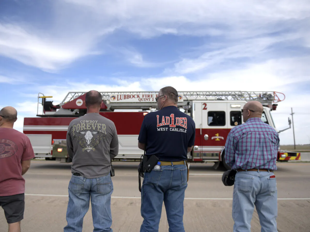 Lubbock county first responders pause as the procession for Fritch Fire Chief Zeb Smith passes by in Lubbock, Texas, on March 5, 2024. (Annie Rice/Lubbock Avalanche-Journal via AP)