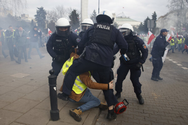 Police officers detain a man during farmers protest in Warsaw, Poland, on Wednesday March 6, 2024. The protest ratchets up pressure on the government as they demand the Poland-Ukraine border closed to food imports and demand changes to European Union climate and agricultural policies. (AP Photo/Michal Dyjuk)
