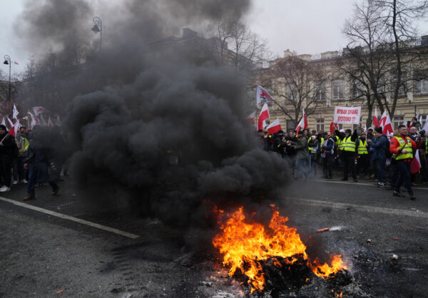 Fire burns in the street as farmers protest outside Polish Prime Minister Donald Tusk's office against the European Union's Green Deal and imports of Ukrainian agricultural products, in Warsaw, Poland, March 6, 2024. REUTERS/Aleksandra Szmigiel