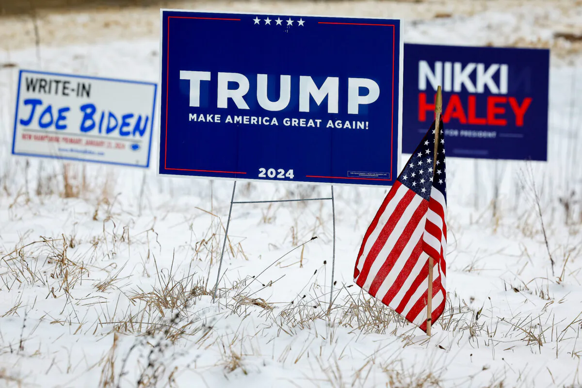 Campaign signs for Republican presidential candidates former President Donald Trump and former United Nations ambassador Nikki Haley stand next to a sign asking voters to write in "Joe Biden," in Loudon, N.H., on Jan. 19, 2024. (Chip Somodevilla/Getty Images)