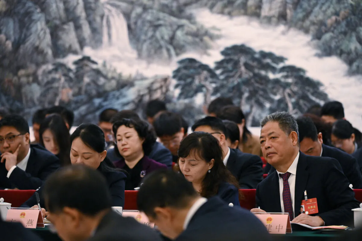 Officials listen to speeches during the Shaanxi delegation meeting at the National People's Congress (NPC) at the Great Hall of the People, in Beijing, on March 6, 2024. (Greg Baker/AFP)