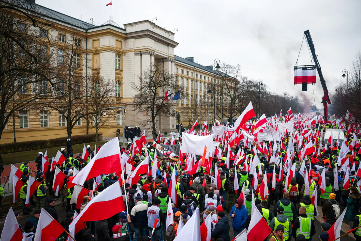 People carry Polish flags and banners, as farmers protest outside Polish Prime Minister Donald Tusk's office against the European Union's Green Deal and imports of Ukrainian agricultural products, in Warsaw, Poland, on March 6, 2024. (Kacper Pempel/Reuters)