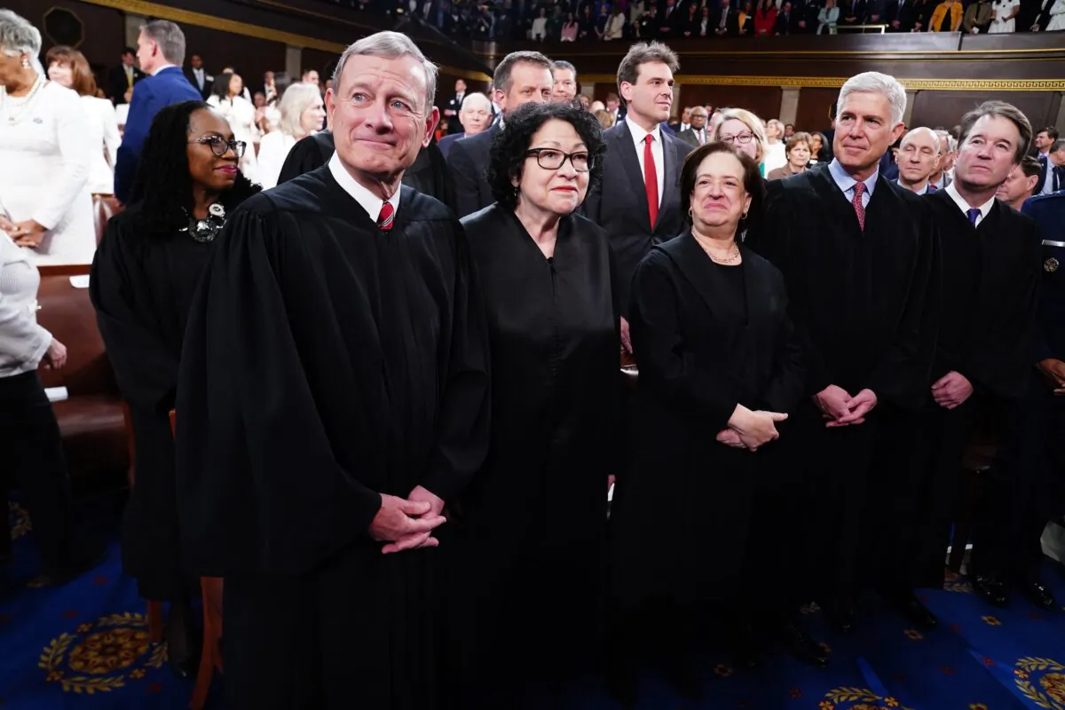 Chief Justice of the Supreme Court John Roberts (L), along with (L–R) Associate Justices Sonia Sotomayor, Elena Kagan, Neil Gorsuch, Brett Kavanaugh, and (back) Ketanji Brown Jackson stand together ahead of President Joe Biden's third State of the Union address to a joint session of Congress in the House Chamber of the U.S. Capitol on March 7, 2024. (Shawn Thew/Pool/AFP via Getty Images)