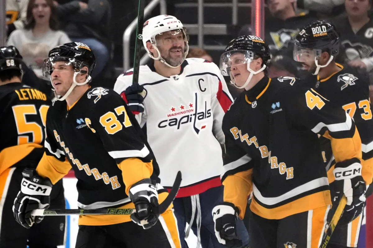 Washington Capitals' Alex Ovechkin (C) celebrates after assisting on a goal by teammate Hendrix Lapierre (not shown) as Pittsburgh Penguins' Sidney Crosby (87) and Valtteri Puustinen skate back to their bench during the second period of an NHL hockey game in Pittsburgh on March 7, 2024. (Gene J. Puskar/AP Photo)