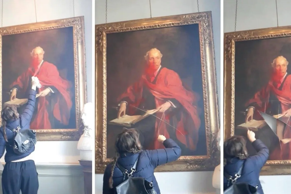 A Palestine Action activist vandalising a painting of Lord Balfour at the University of Cambridge in Cambridge, England, on March 8, 2024. (Courtesy of Palestine Action)