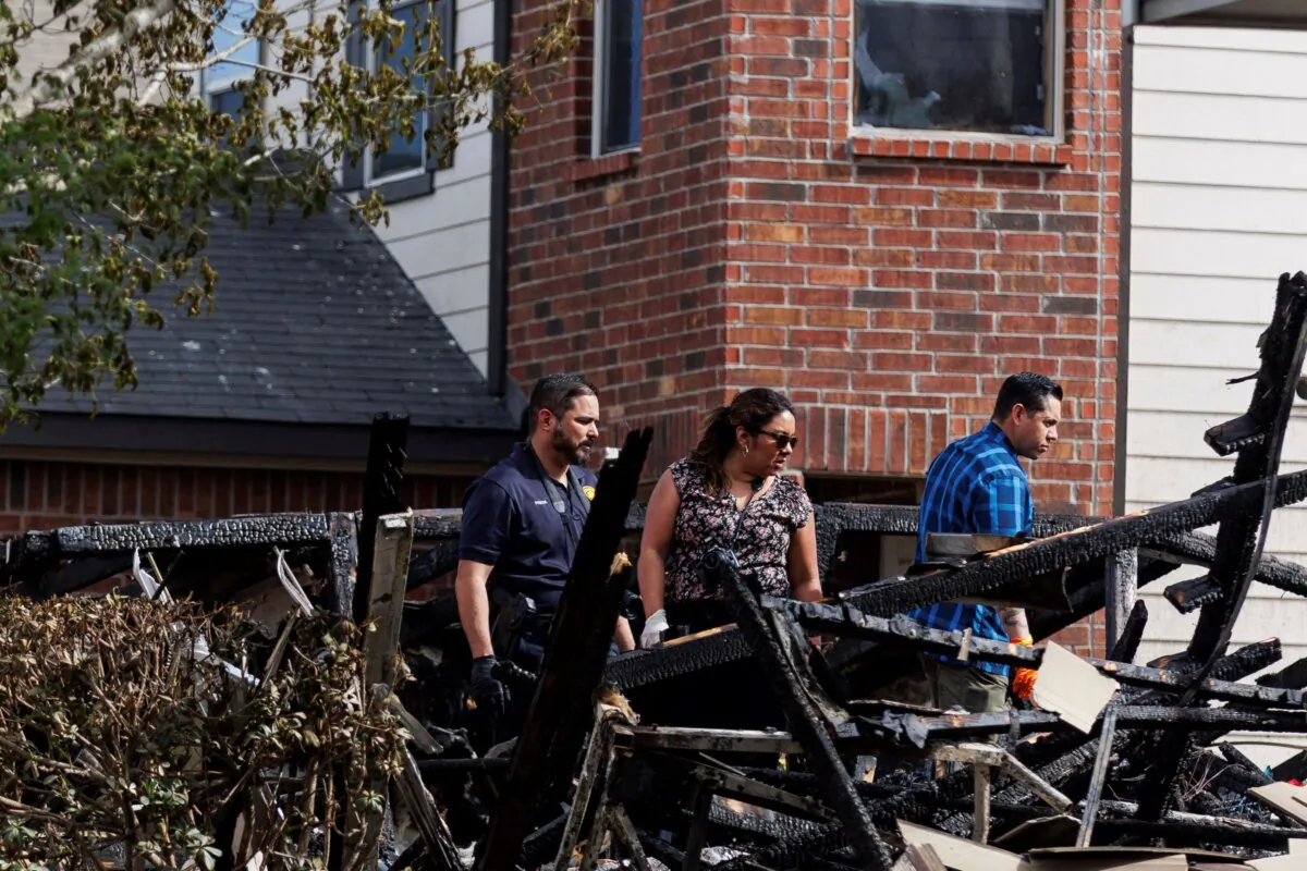 San Antonio police officers and firefighters investigate the scene of a house fire in the 4400 block of Wrangler Run, on the far southeast side of San Antonio on March 8, 2024. (Sam Owens/The San Antonio Express-News via AP)