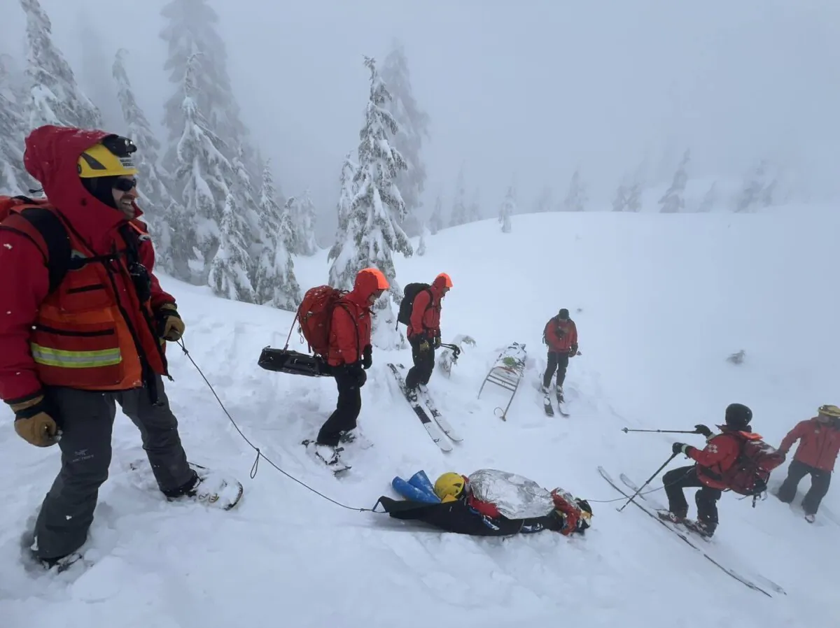 Rescuers work to move a person, bottom centre, to safety along a trail near Pump Peak, in North Vancouver, B.C., in a handout photo on Mar.10, 2024. (The Canadian Press/HO-North Shore Rescue)