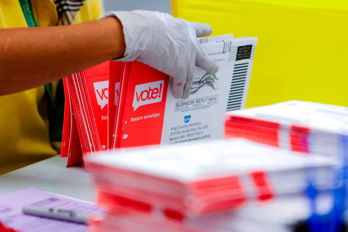 An election worker opens envelopes containing vote-by-mail ballots in a file photo. (Jason Redmond/AFP via Getty Images)