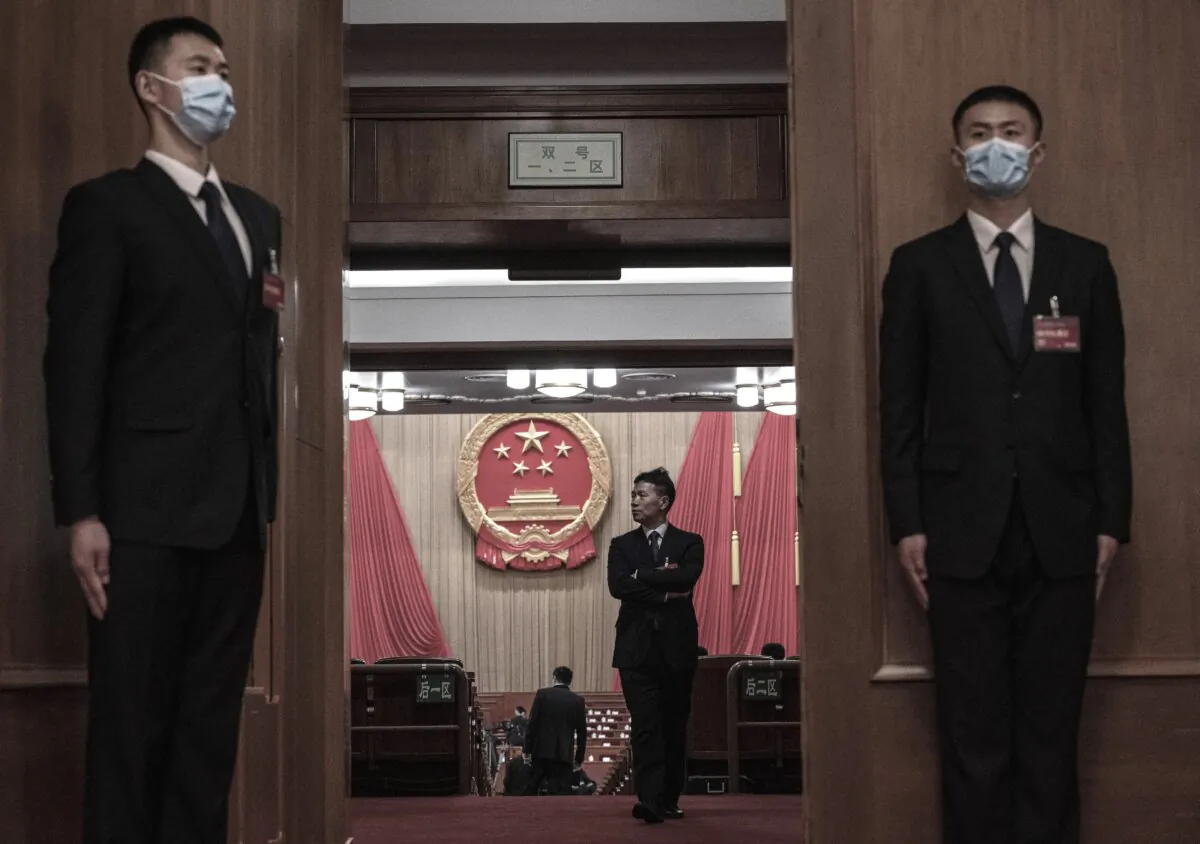 Security stand at the doorway as a delgate walks in the auditorium before the opening of the NPC, or National People’s Congress at the Great Hall of the People on March 5, 2024 in Beijing, China. (Kevin Frayer/Getty Images)