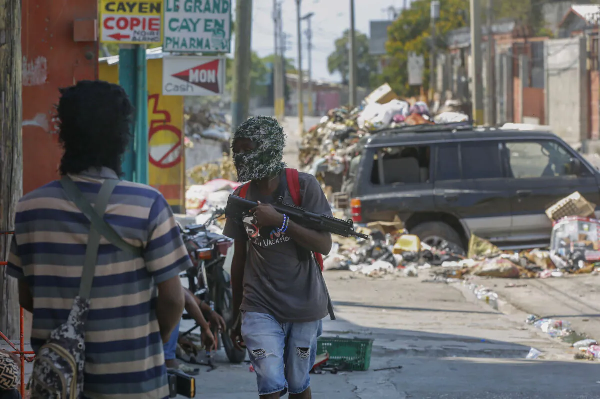 Armed members of the G9 and Family gang stand guard at their roadblock in the Delmas 6 neighborhood of Port-au-Prince, Haiti, on March 11, 2024. (The Associated Press/Odelyn Joseph)