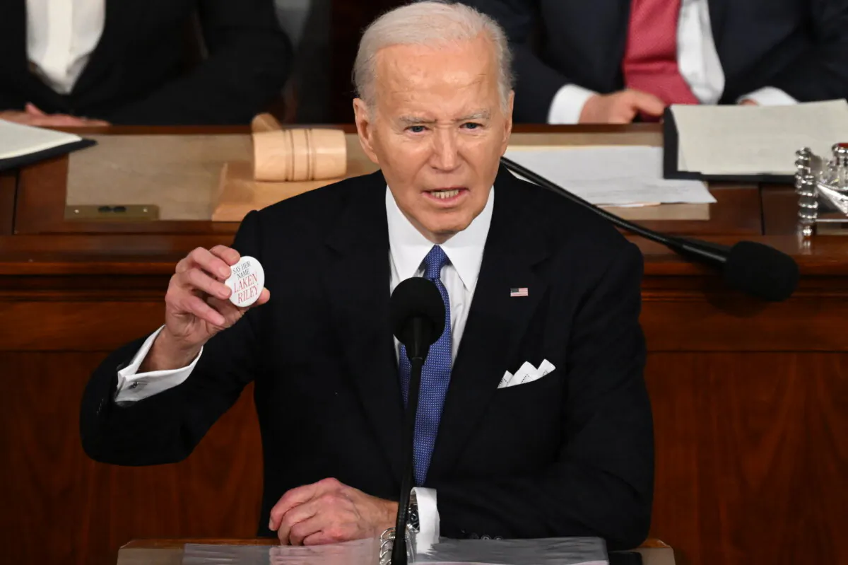 President Joe Biden holds a “Say her name Laken Riley” button while delivering the State of the Union address in the House Chamber of the U.S. Capitol in Washington on March 7, 2024. (Saul Loeb/AFP via Getty Images)