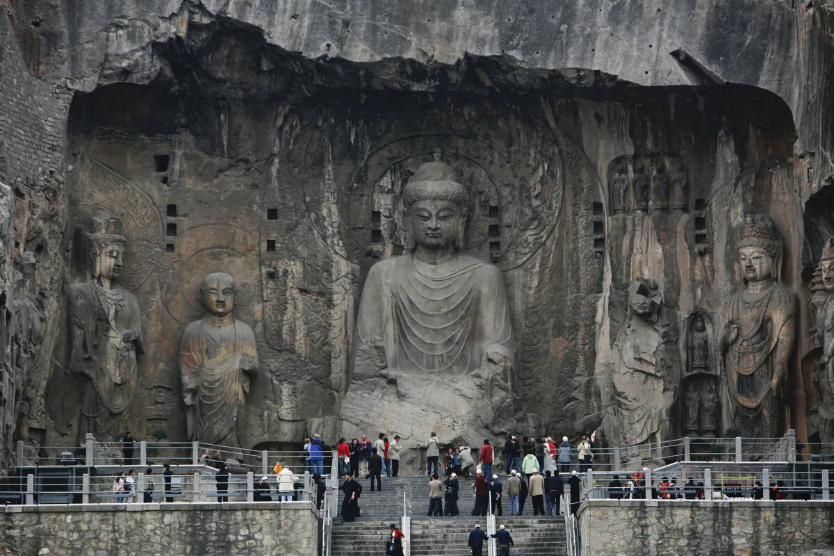 Tourists view Buddhist sculptures at Longmen Grottoes in the outskirts of Luoyang of Henan Province, China, on April 5, 2007. (China Photos/Getty Images)