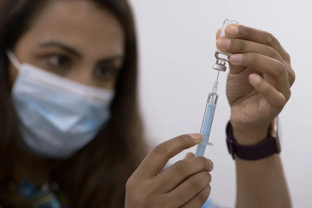 A volunteer draws the AstraZeneca vaccine as members of the public have their COVID-19 vaccinations at Fazl Mosque in Southfields, London, as it hosts a drop in clinic on June 8, 2021. (Dan Kitwood/Getty Images)