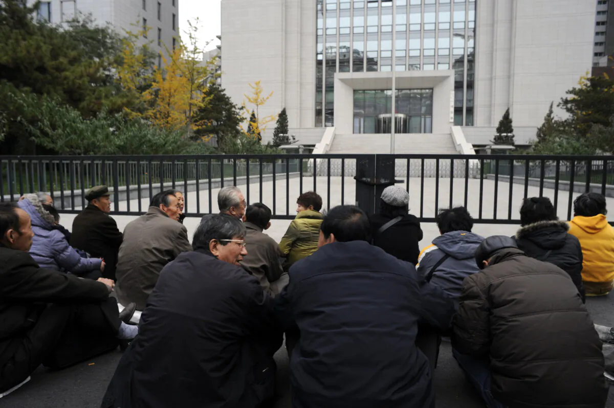A group of elderly retirees from northeast Liaoning Province stage a sit-down protest outside the Ministry of Justice over their unpaid pensions, in Beijing on Nov. 8, 2011.(Goh Chai Hin/AFP via Getty Images)