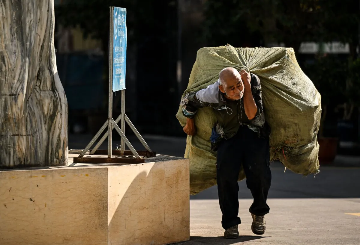 An elderly man carries a bag of recyclable materials on his back in Ruili, west Yunnan Province, in China on Jan. 13, 2023. (Noel Celis/AFP via Getty Images)