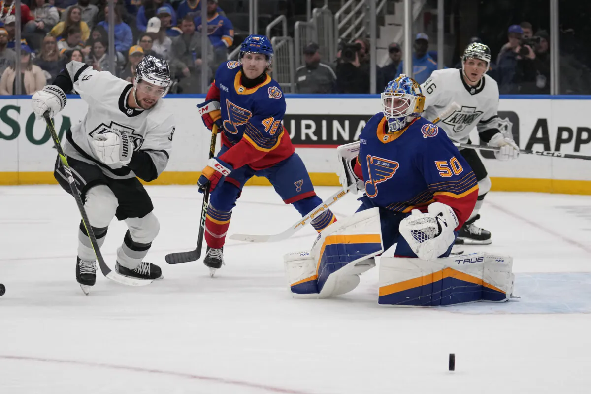 St. Louis Blues goaltender Jordan Binnington deflects a puck as teammate Scott Perunovich and Adrian Kempe of the Los Angeles Kings watch in St. Louis on March 13, 2024. (Jeff Roberson/AP Photo)