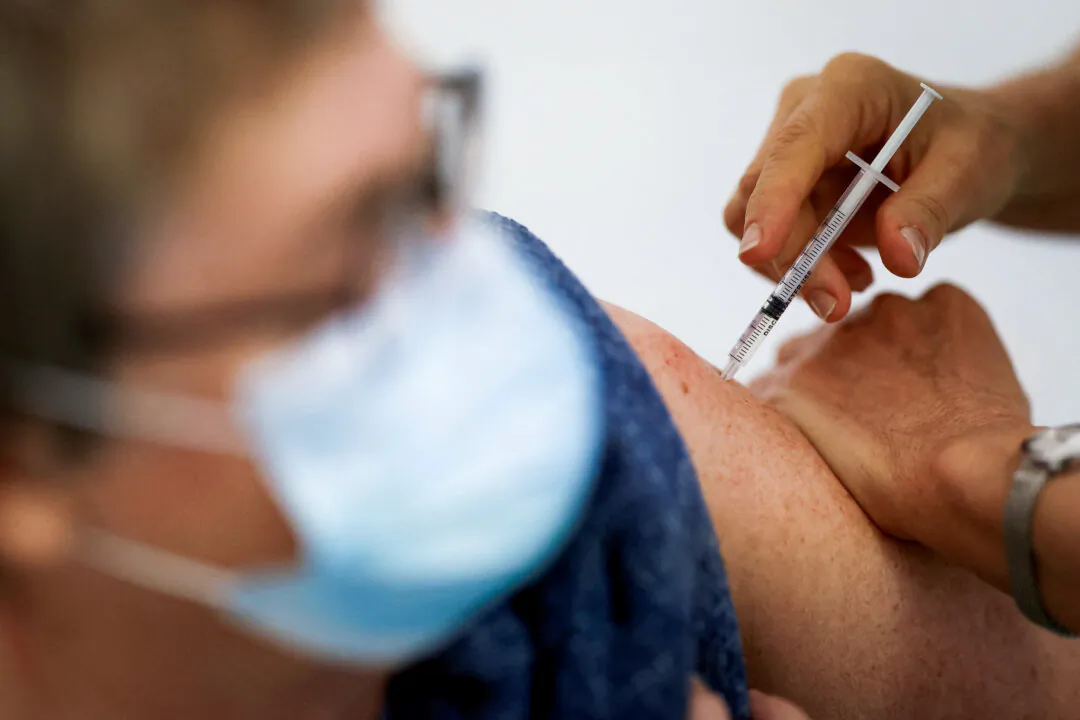 A medical worker administers a dose of the Pfizer-BioNTech COVID-19 vaccine to a patient at a vaccination center in Ancenis-Saint-Gereon, France, on Nov. 17, 2021. (Stephane Mahe//Reuters)