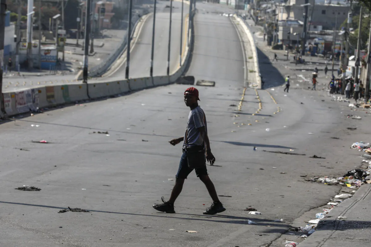 A pedestrian crosses a street free of traffic in Port-au-Prince, Haiti, on Mar. 13, 2024. (The Canadian Press/AP-Odelyn Joseph)