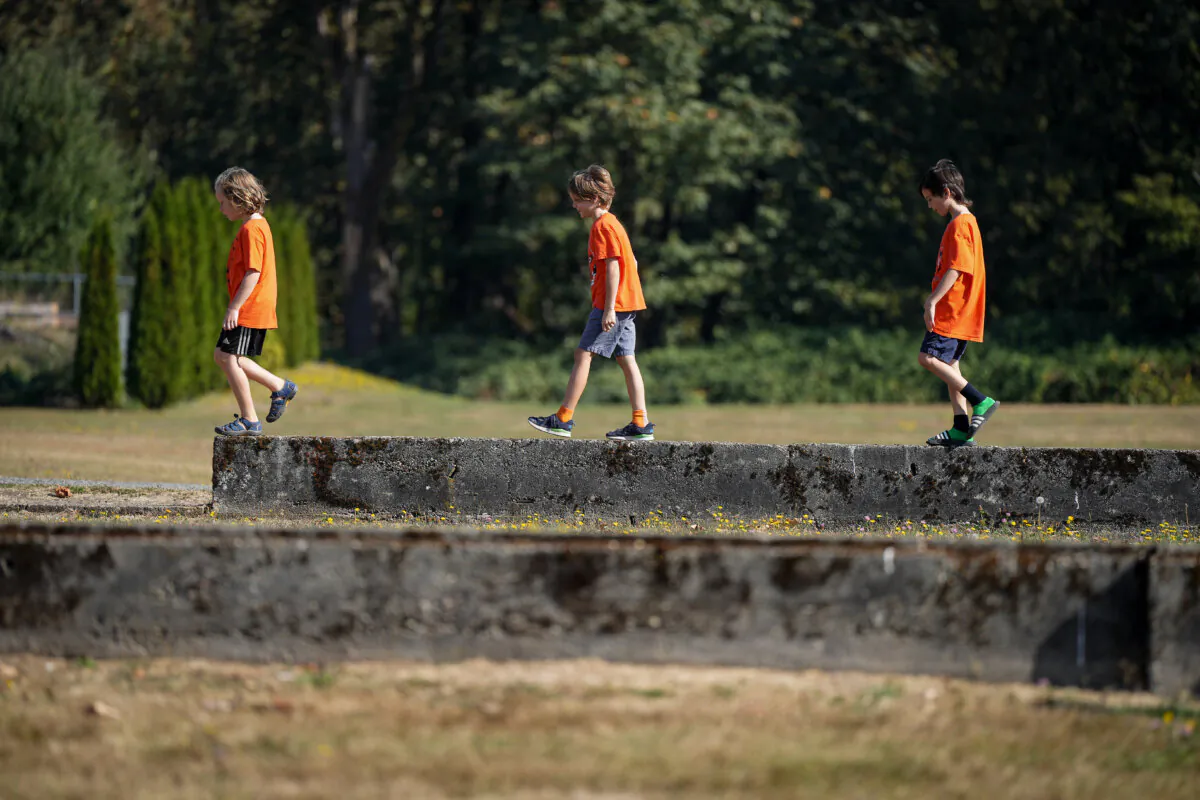 Children walk on the foundation wall of a former building at the site of the former St. Mary's Indian Residential School during a ceremony to mark the National Day for Truth and Reconciliation, in Mission, B.C., on Sept. 30, 2022. (The Canadian Press/Darryl Dyck)