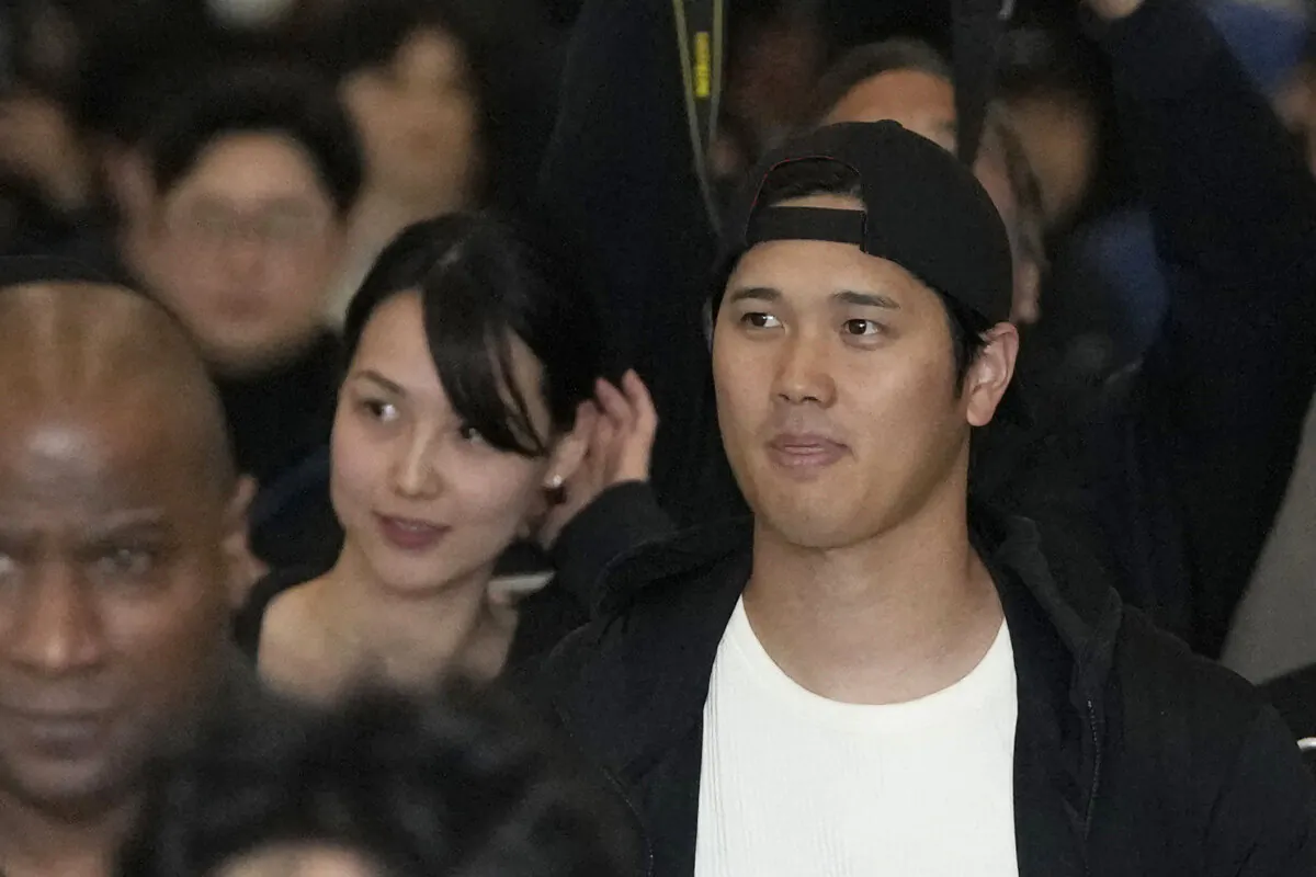 Los Angeles Dodgers' Shohei Ohtani and his wife Mamiko Tanaka walk with security during the baseball team's arrival at Incheon International Airport in Incheon, South Korea, on March 15, 2024. (Lee Jin-man/AP Photo)