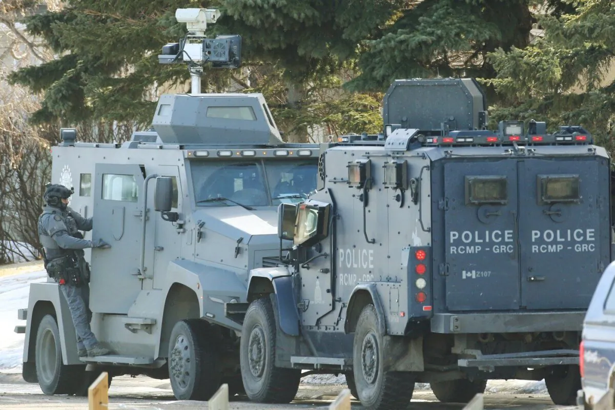 Calgary Police and RCMP tactical team members keep watch on a house where shots were fired. Residents of an east-end Calgary neighbourhood were being told to stay away as a standoff stretched into its second day, in Calgary, Alta., March. 15, 2024. (The Canadian Press/Dave Chidley)
