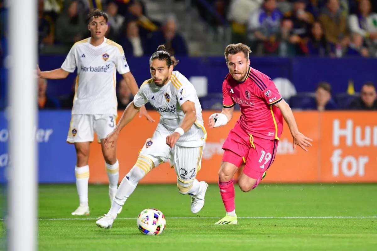 LA Galaxy defender Martin Caceres (22) and St. Louis City SC midfielder Indiana Vassilev (19) chase down the ball during the first half in Carson, Calif., on March 16, 2024. (Gary A. Vasquez/USA TODAY Sports via Field Level Media)